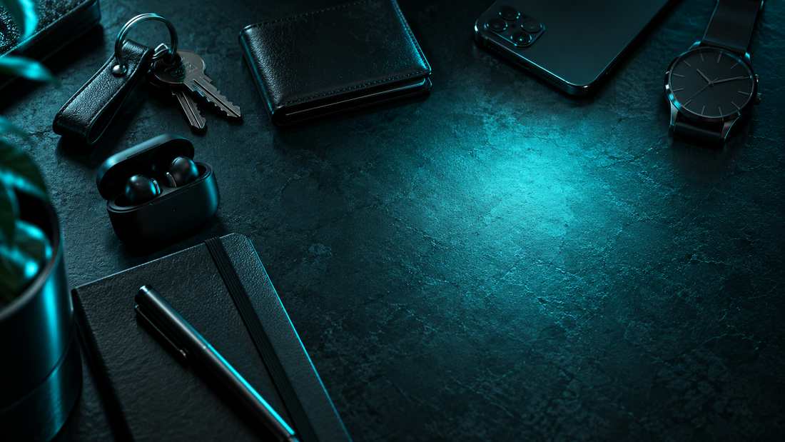 Everyday carry items on a dark desk with a pool of cyan light where a flashlight would sit