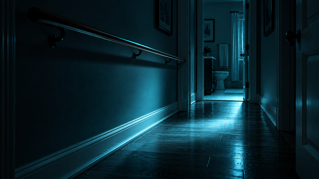 Dark home hallway with a softly lit cyan path along the floor and a wooden handrail